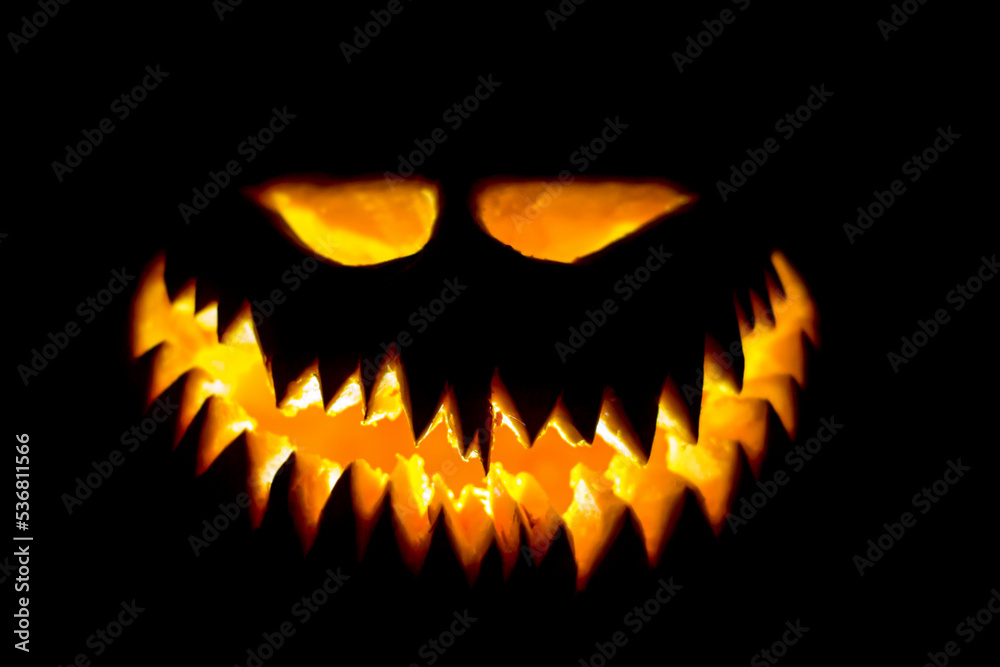 Fototapeta premium Halloween pumpkin glowing face in the dark.