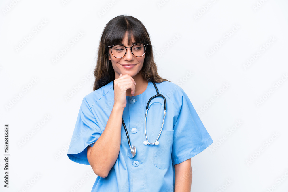 Young caucasian nurse woman isolated on white background looking to the side and smiling