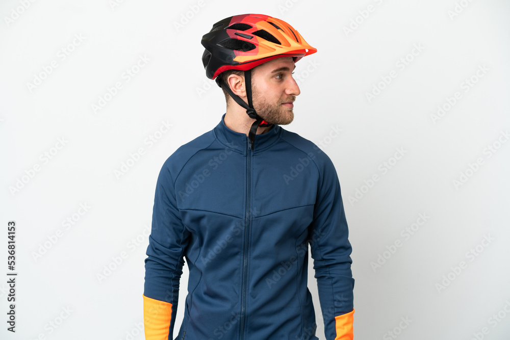 Young cyclist man isolated on white background looking to the side Young cyclist man isolated on white background looking to the side