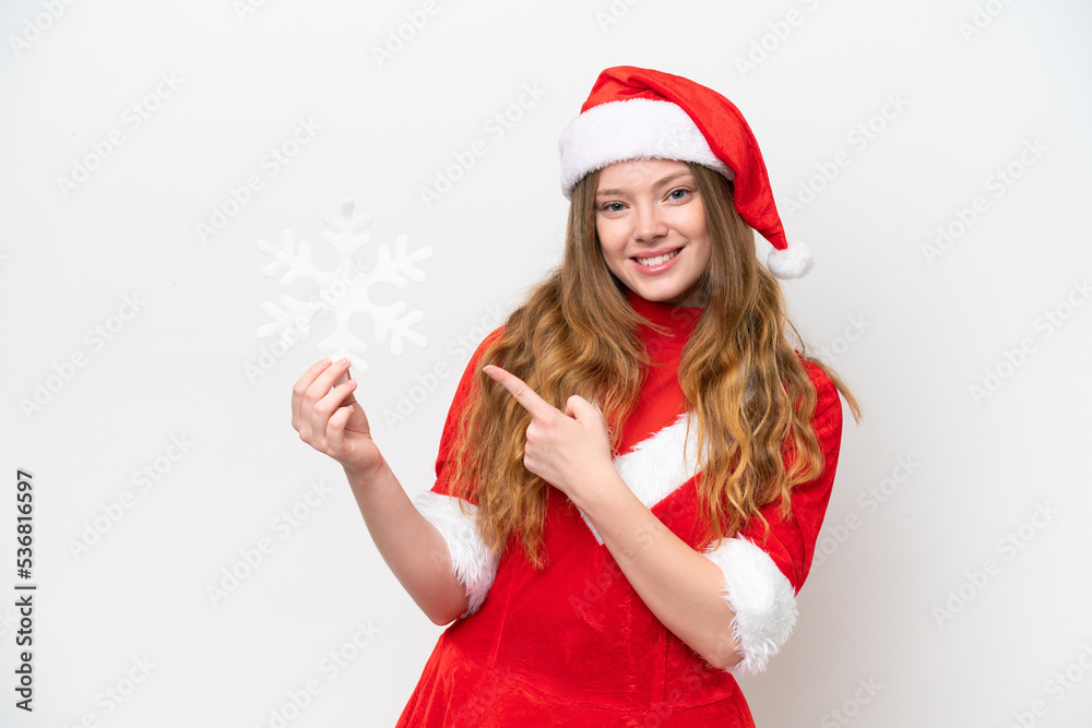 Young caucasian woman with Christmas dress holding snowflake isolated on white background and pointing it Young caucasian woman with Christmas dress holding snowflake isolated on white background and pointing it