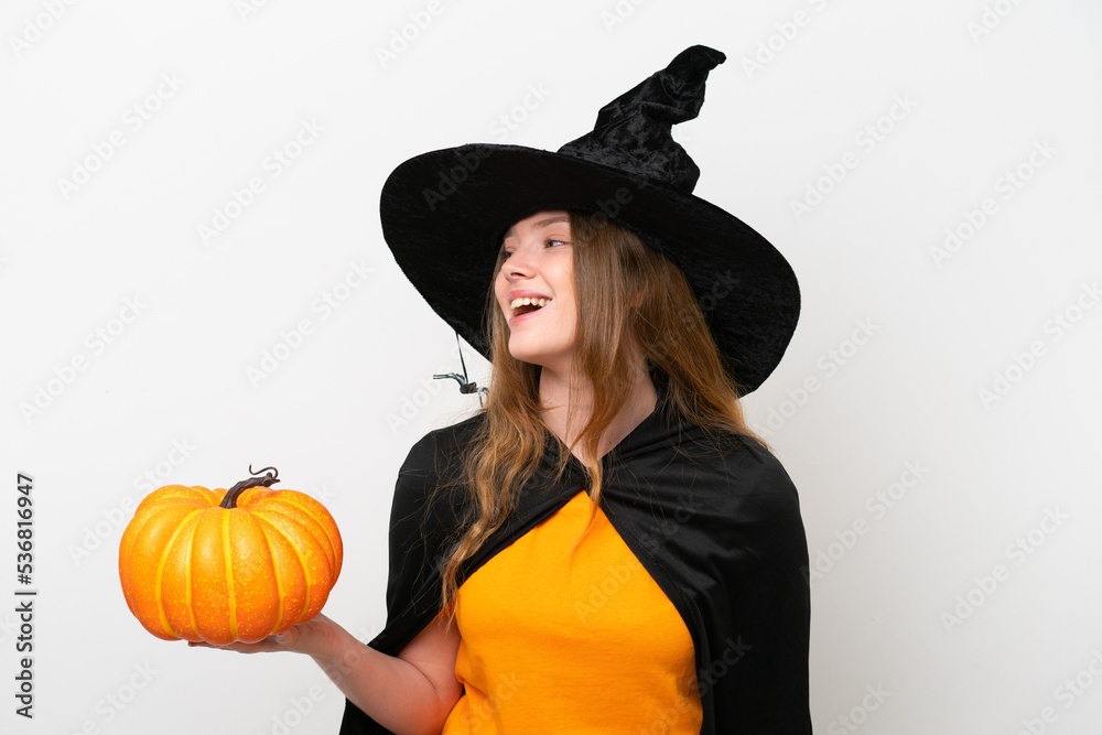Young pretty woman costume as witch holding a pumpkin isolated on white background laughing in lateral position Young pretty woman costume as witch holding a pumpkin isolated on white background laughing in lateral position
