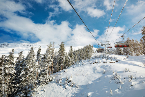 Obraz na płótnie Sunny day at a ski resort. A ropeway over the forest w salonie