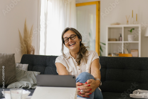 Adult woman having video call at home using tablet
