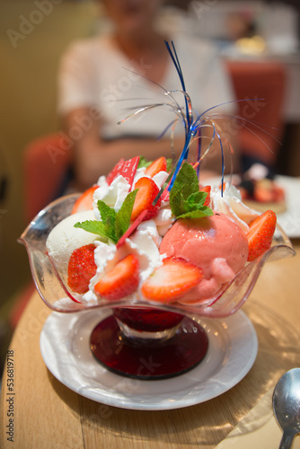 Delicious cup with ice cream, strawberries and whipe cream.