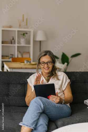 Adult woman having video call at home using tablet