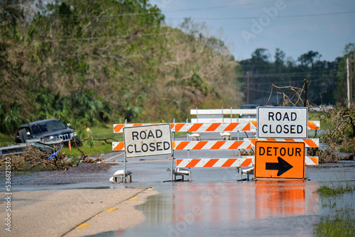 Hurricane Ian flooded street with road closed signs blocking driving of cars. Safety of transportation during natural disaster concept