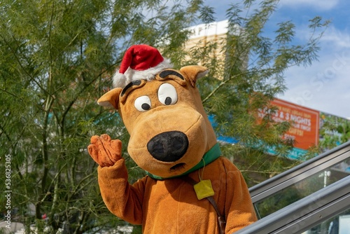 Closeup shot of a person wearing a Scooby Doo costume while waving their hand photo