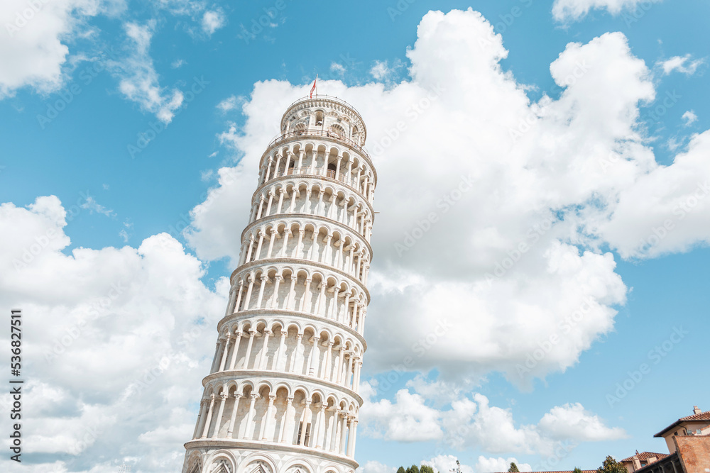 Amazing beautiful white tilted tower against the blue cloudy sky in Pisa. Travel and vacations in Italy