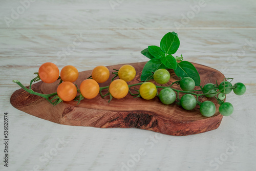 Yellow tomatoes branch on table  background, healthy food photo