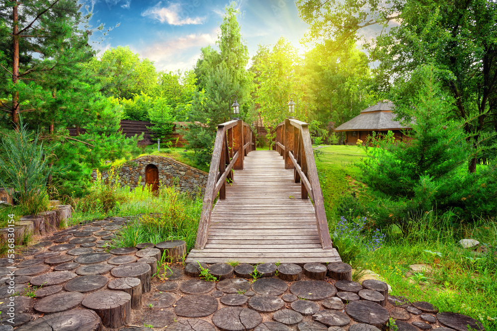 Wooden decorative bridge in the estate with landscaping in day