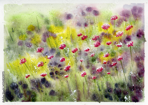 Watercolor painting on rough paper of a field of wildflowers or flowers growing in a summer garden.