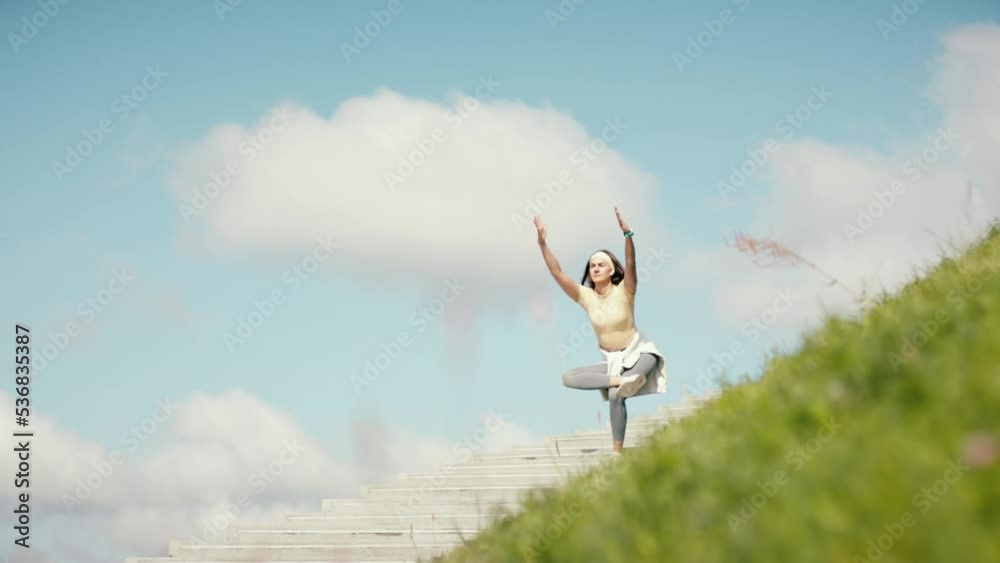 Fitness young adult woman making yoga and pilates pose on stairs. Female workout on sky background. Amazing sky view training. Stairs to haven. Fitness young adult woman making yoga and pilates pose on stairs. Female workout on sky background. Amazing sky view training. Stairs to haven.
