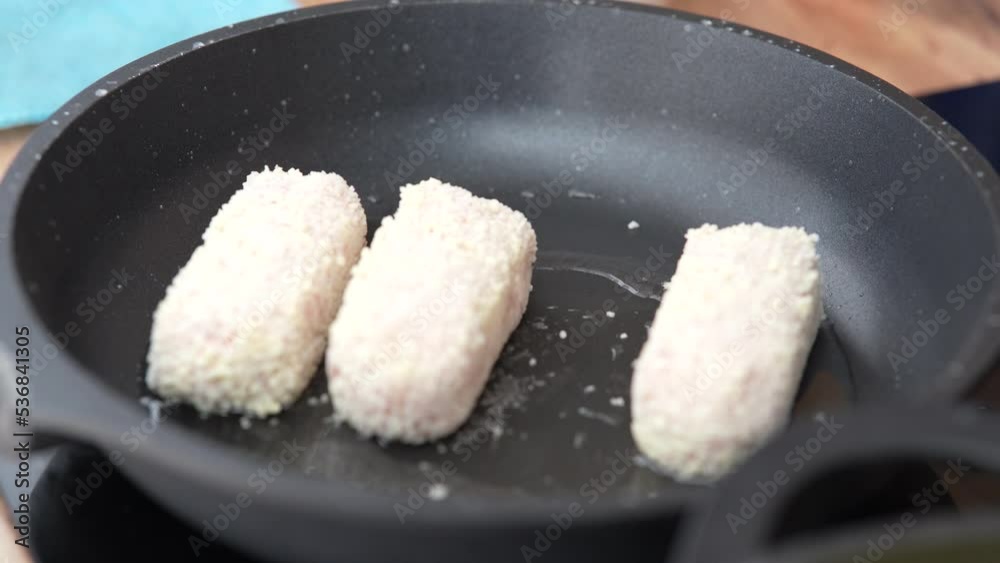 Meat cutlets are fried in pan. Chicken cutlets are fried in a black frying pan.