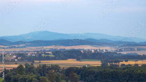 Rural landscape, green fields and small mountains in the background