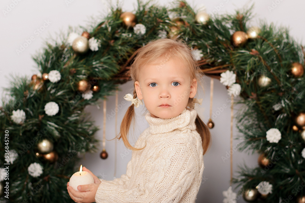 Cute girl in a Christmas decorated studio in pastel colors. Luxurious Christmas decoration. Merry Christmas and Happy New Year. Cute girl in a Christmas decorated studio in pastel colors. Luxurious Christmas decoration. Merry Christmas and Happy New Year.