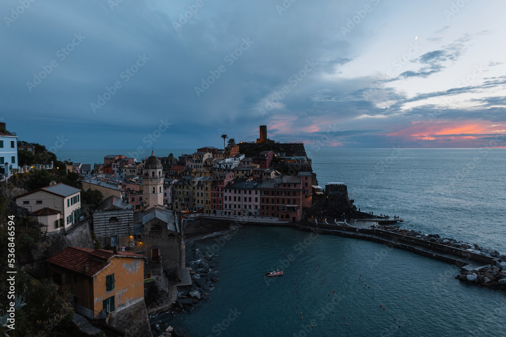 Amazing famous beautiful little Italian village of Vernazza by the sea at sunset in the evening. Traveling in Europe, Italy. Beautiful view of an ancient fishing town. Romantic European place