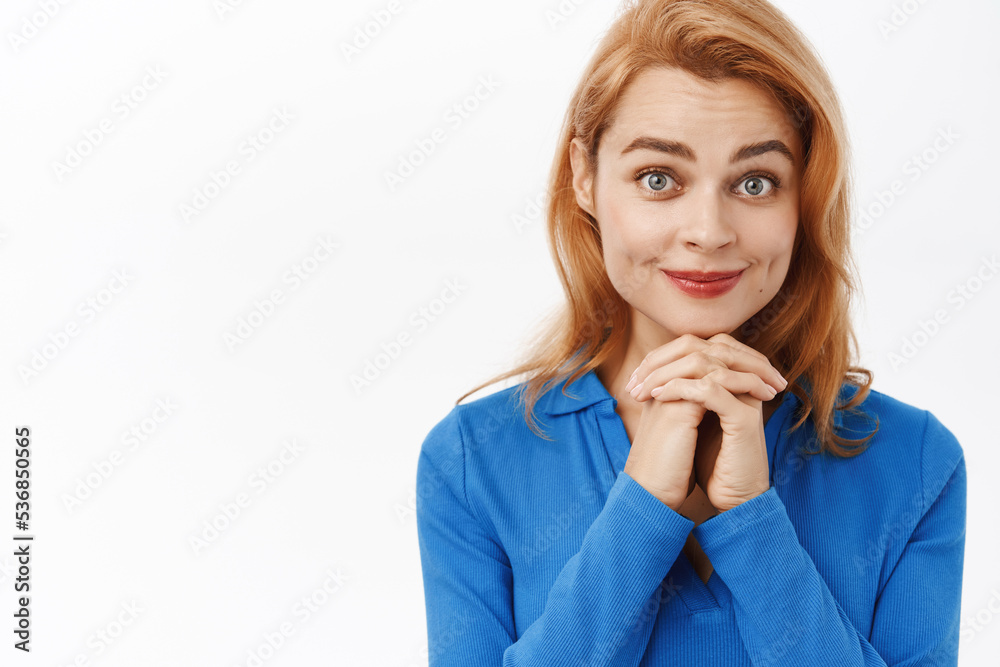 Close up portrait of young smiling woman looking with tenderness and care, hoping for something, anticipating, standing over white background Close up portrait of young smiling woman looking with tenderness and care, hoping for something, anticipating, standing over white background
