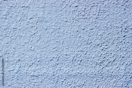 Plastered and painted uneven surface wall. Concrete texture of light blue color