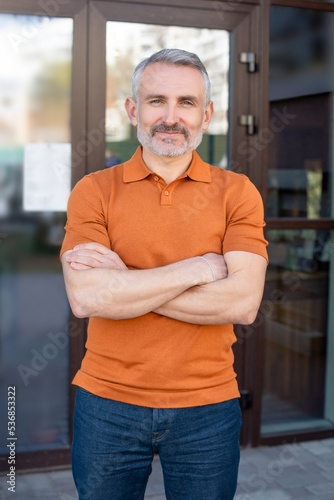 Принти на полотні Confident mature blue-eyed man with his arms crossed