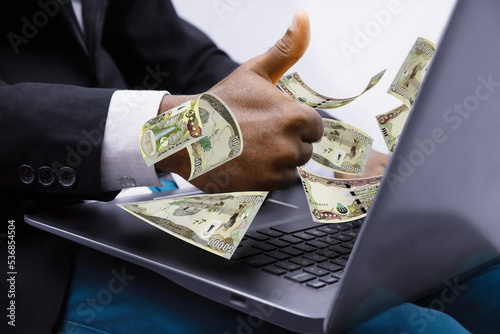 Iraqi dinar notes coming out of laptop with Business man giving thumbs up, Financial concept. Make money on the Internet, working with a laptop