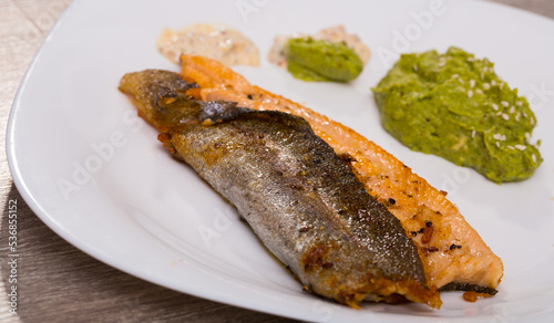 Healthy eating. Grilled fillets of trout served with broccoli puree and creamy sauce..