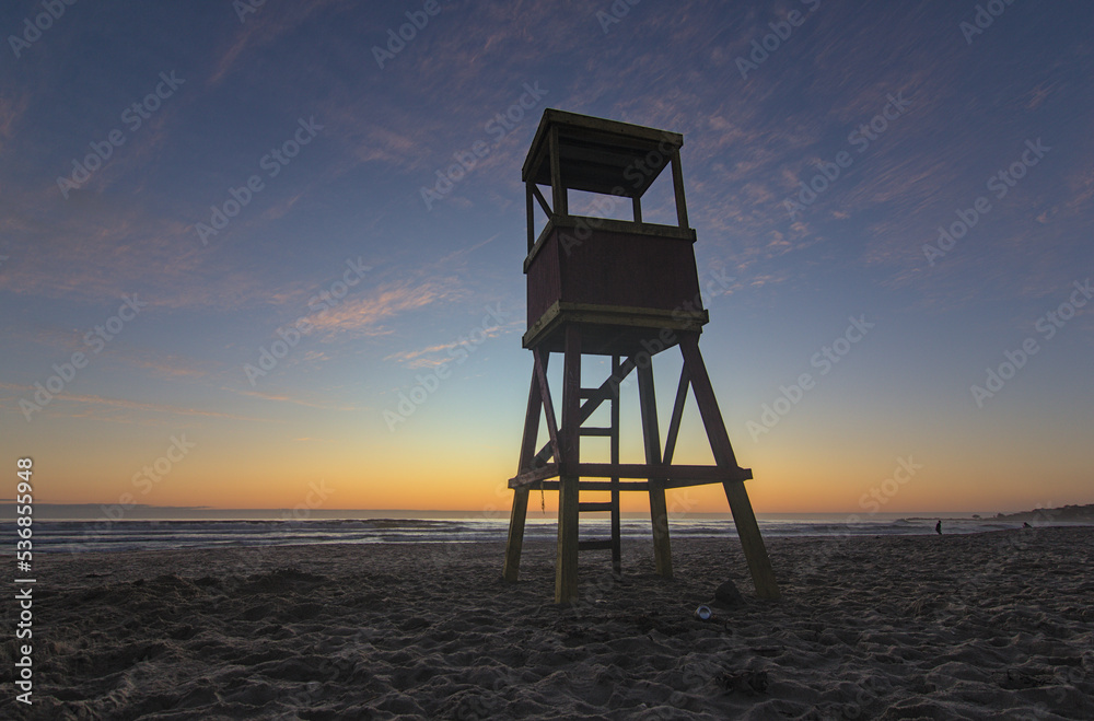 sundown on the beach with the beginning of the blue hour with the lifeguard hut in the foreground