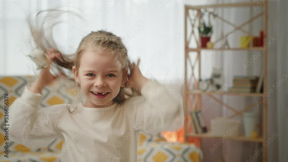 Kid girl has fun making ears with hands and fumbling hair. Preschooler girl in white dress has fun making big ears with hands and fumbling hair. Happy blonde kid sticks out tongue and smiles beamly Kid girl has fun making ears with hands and fumbling hair. Preschooler girl in white dress has fun making big ears with hands and fumbling hair. Happy blonde kid sticks out tongue and smiles beamly