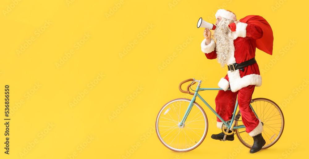 Fototapeta premium Santa Claus with megaphone riding bicycle on yellow background with space for text