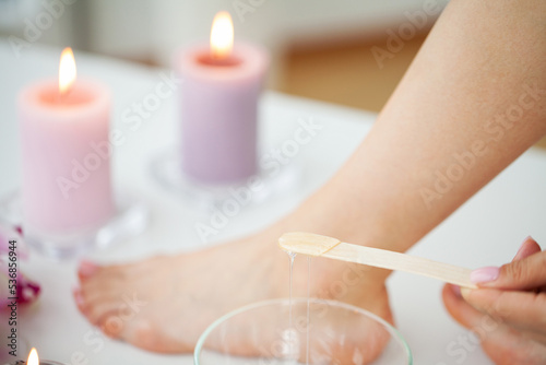 Woman holding bowl with hot wax for depilation epilation hair removal procedure