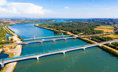 Scenic aerial view of three bridges across Rhone river near small French town of Roquemaure in Gard department in sunny day photo