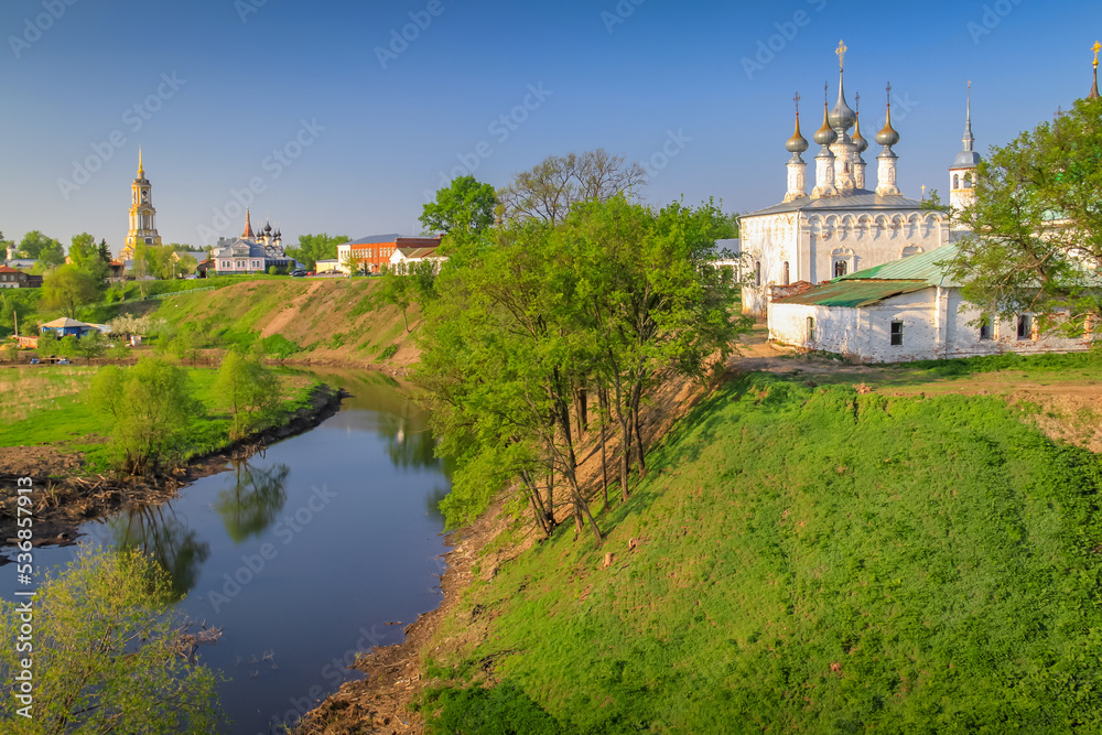 Orthodox church at golden sunrise with river, Suzdal, Russia