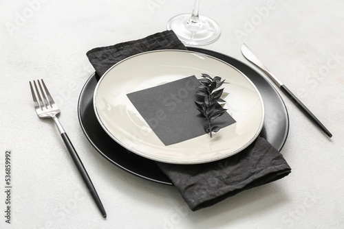Elegant table setting with blank card on light background