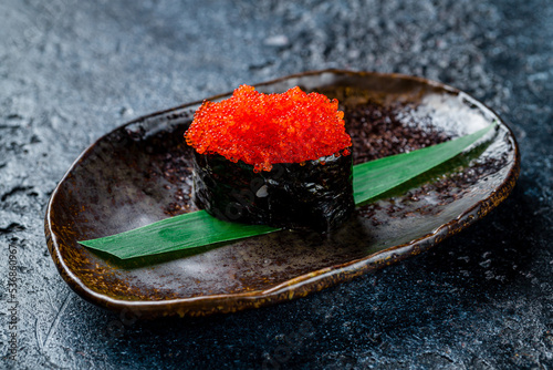 gunkan with masago caviar on dark stone table