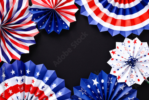 Paper fans in American flag colors on black background. Veterans Day, Memorial Day, US Independence Day banner template