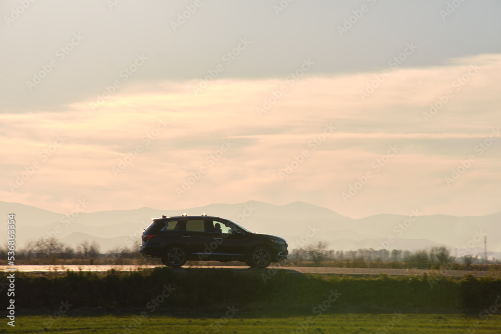 Naklejka premium Car driving fast on intercity road at sunset. Highway traffic in evening