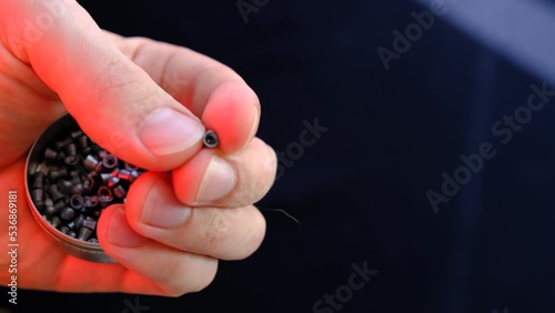 air gun pellets on the mans hand with red light for illumination. Man showing the air gun bullets in his hand. photo