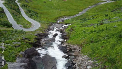 Aerial flying down above sendefossen river in Vikafjell norway - Beautiful landscape and river closy to rv13 curvy mountain road on left side photo