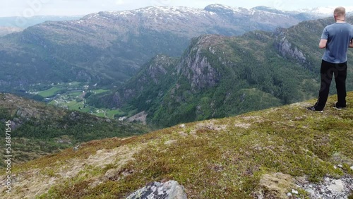Aerial approaching and passing trail runner while enjoying spectacular view - Eidslandet village below and Leirovatnet freshwater lake in Vaksdal Norway photo