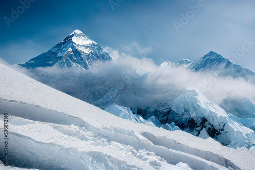 A beautiful scenic landscape with a snow-covered mountain peak covered by a veil of clouds photo