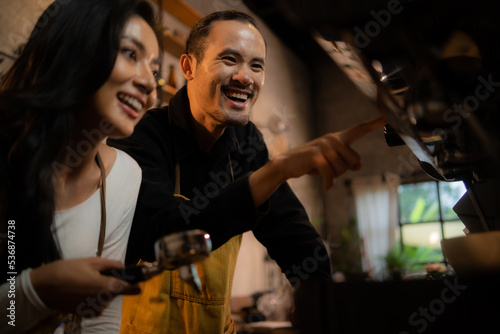 Barista training staff using coffee matchine in coffee shop cafe © Artorn