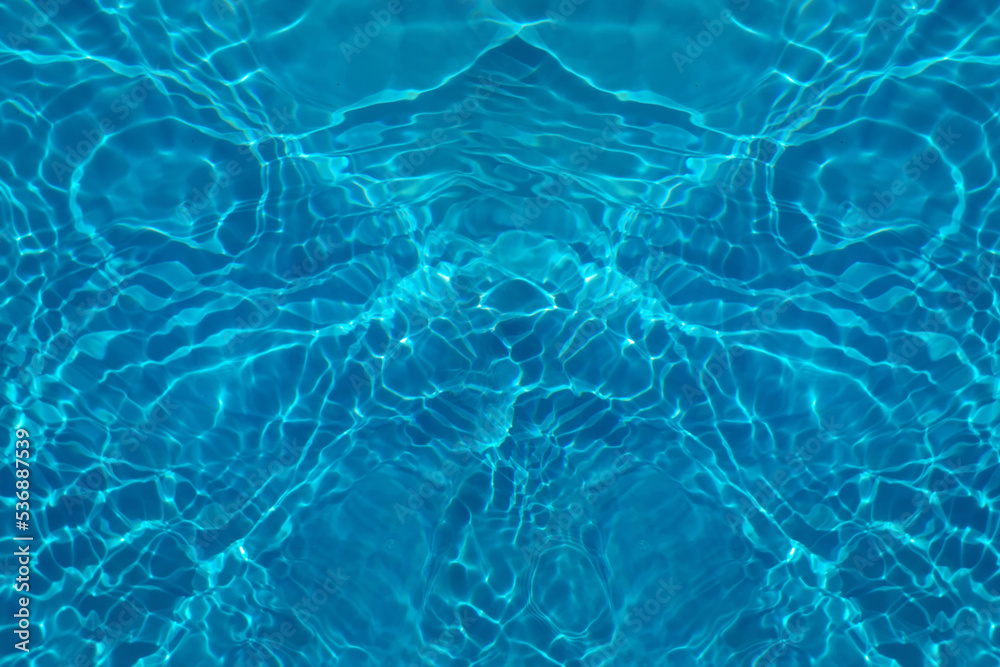 Defocus blurred transparent blue colored clear calm water surface texture with splash, bubble. Shining blue water ripple background. Surface of water in swimming pool. Blue bubble water shining. Defocus blurred transparent blue colored clear calm water surface texture with splash, bubble. Shining blue water ripple background. Surface of water in swimming pool. Blue bubble water shining.