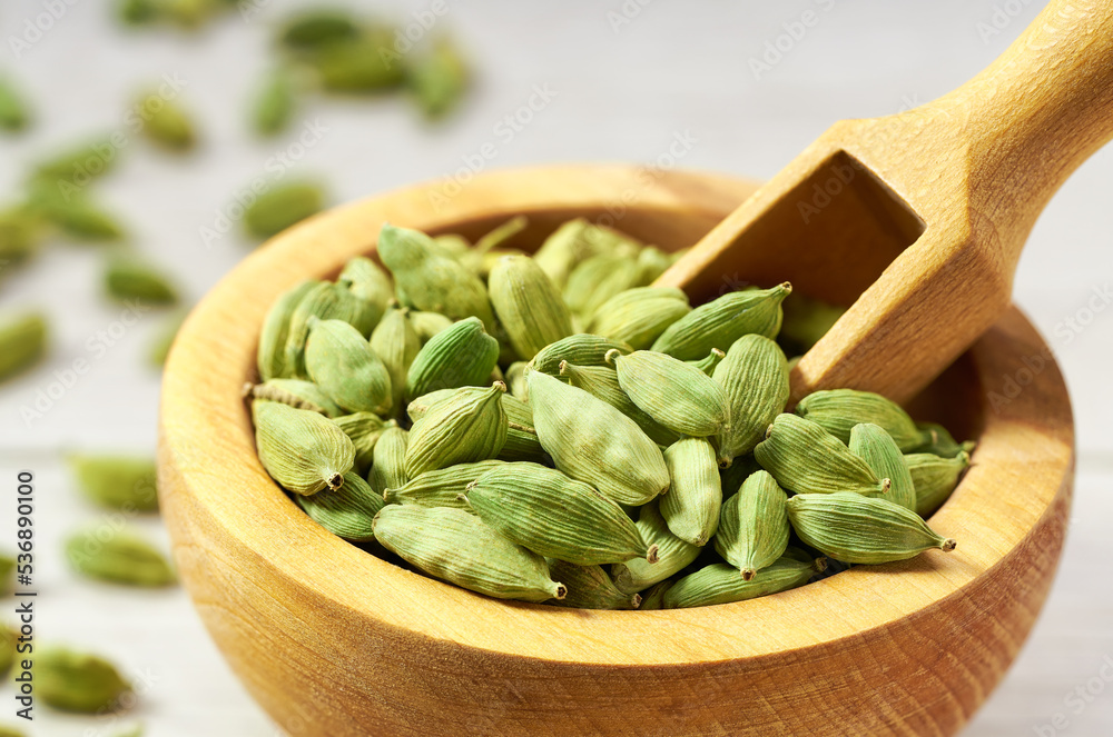 Cardamom pods on a white wooden kitchen table, close up. Cardamom pods on a white wooden kitchen table, close up.