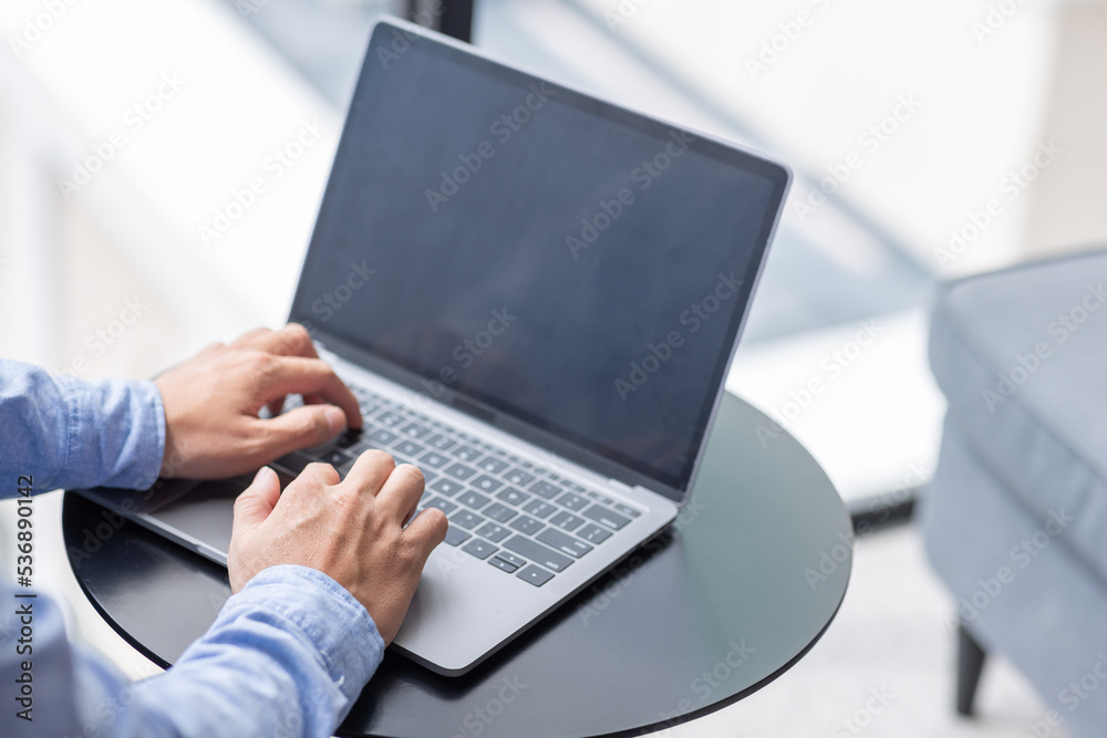 Young man working on he laptop with blank copy space screen for your advertising text message in office, Back view of business man hands busy using laptop at desk. Young man working on he laptop with blank copy space screen for your advertising text message in office, Back view of business man hands busy using laptop at desk.