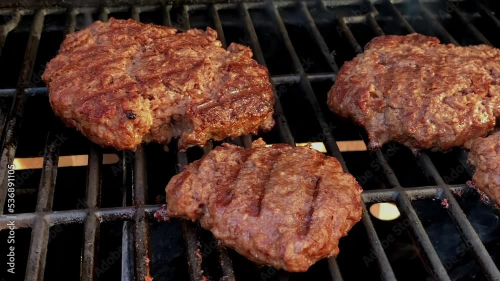Some hamburger patties cooking on a barbecue grill. Some hamburger patties cooking on a barbecue grill.