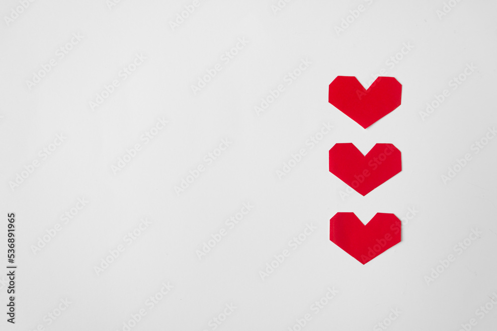 Three red paper hearts isolated on white background. Minimalism. Valentine's Day concept.