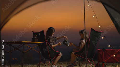 Young Asian woman pours coffee into a coffee cup, Vacations Camping trip, Travel. Screen capture from video