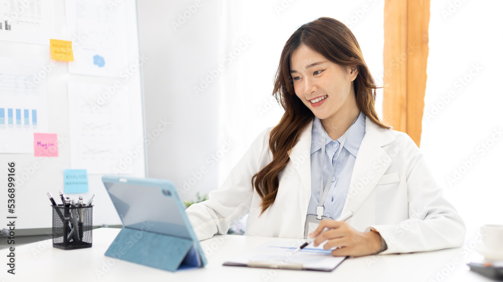 Businesswoman using laptop to work, Asian woman working in the office, Financial clerk or accountant with documents and equipment working on the desk, Using tablet for financial transactions. Businesswoman using laptop to work, Asian woman working in the office, Financial clerk or accountant with documents and equipment working on the desk, Using tablet for financial transactions.