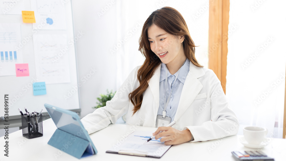Businesswoman using laptop to work, Asian woman working in the office, Financial clerk or accountant with documents and equipment working on the desk, Using tablet for financial transactions. Businesswoman using laptop to work, Asian woman working in the office, Financial clerk or accountant with documents and equipment working on the desk, Using tablet for financial transactions.