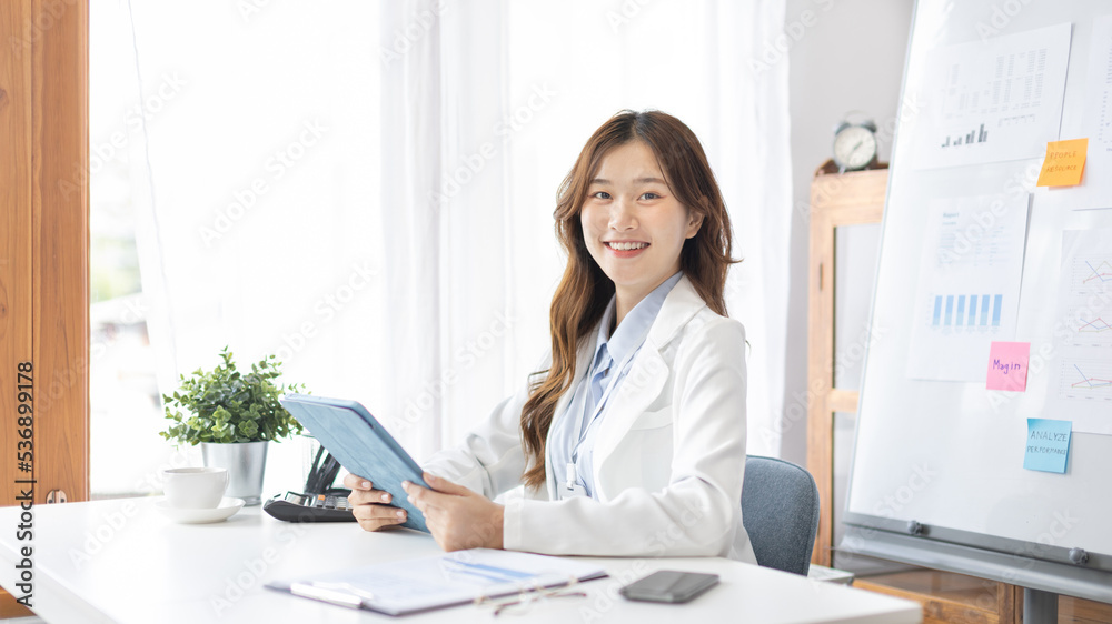 Businesswoman using laptop to work, Asian woman working in the office, Financial clerk or accountant with documents and equipment working on the desk, Using tablet for financial transactions. Businesswoman using laptop to work, Asian woman working in the office, Financial clerk or accountant with documents and equipment working on the desk, Using tablet for financial transactions.
