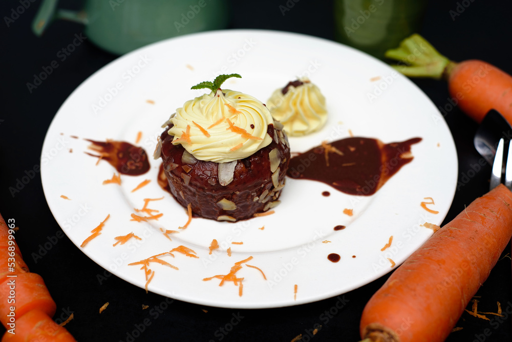 Hands holding a plate with Carrot chocolate cake 